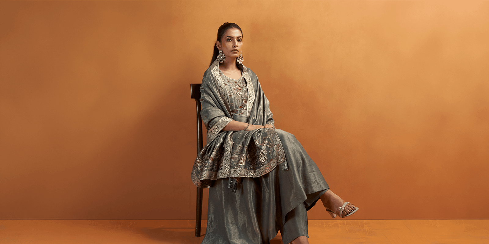Woman wearing a premium grey ethnic suit with intricate embroidery for festive and elegant occasions